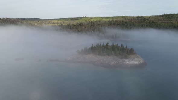 Aerial footage of an isle at split rock light house during a foggy sunny summer morning