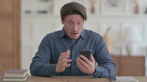 Upset Man Reacting to Loss on Smartphone