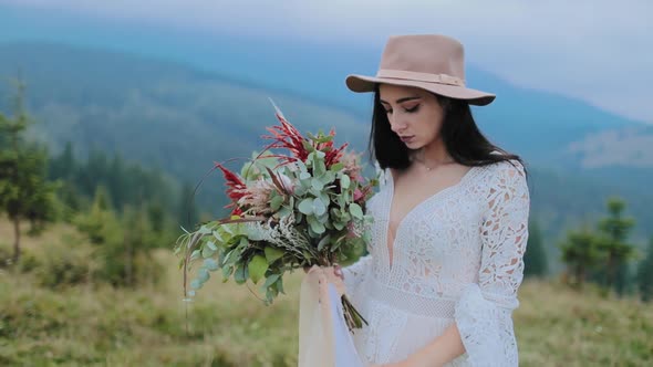 Sad girl with flowers in mountains background
