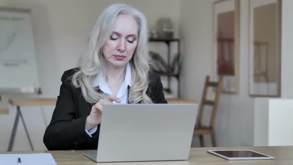 Middle Aged Businesswoman Thinking and Working on Laptop