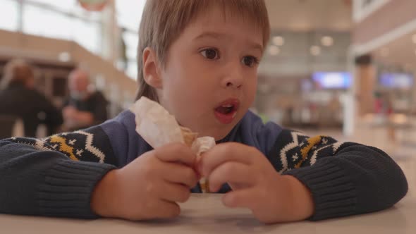 Little Boy Eats Ice Cream in Mall