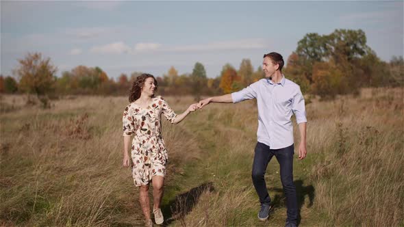 Young Couple in Love Holding Hands Together in Forest.