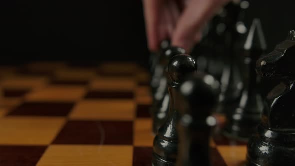 Human's Hand Makes First Opponent Move By Black Pawn E7 E5 in Chess Game