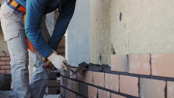 bricklayer lays bricks, exterior wall