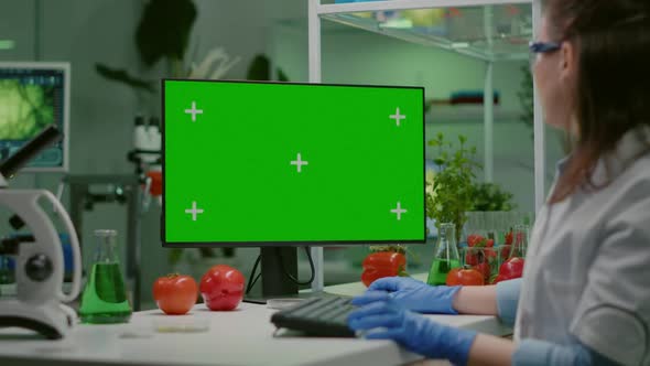 Scientist Woman Working on Computer with Mock Up Green Screen