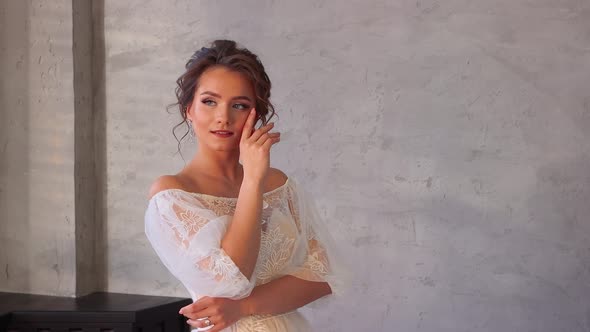 A Girl in a White Dress Smiles and Poses Hands at Her Head