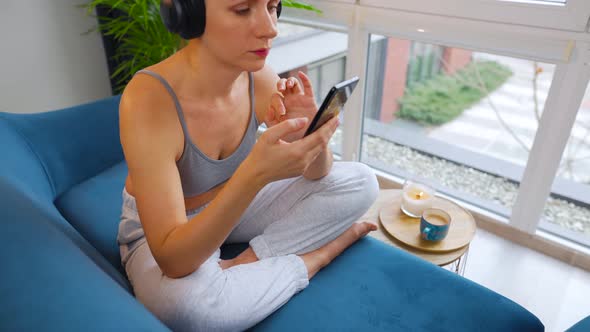 Woman in Wireless Headphones Listening to Music and Using Mobile Apps or Communicates on Social