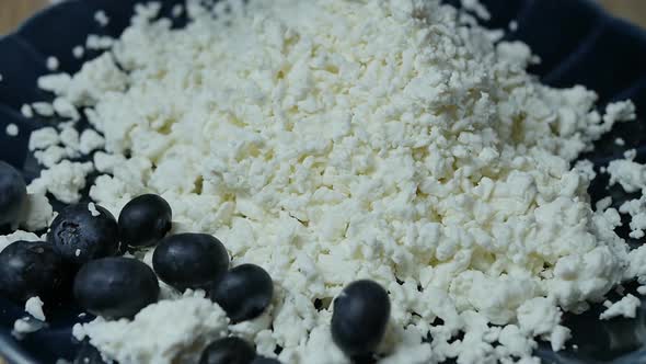 Large Blueberries Fall Into the Curd in a Blue Bowl Slow Motion