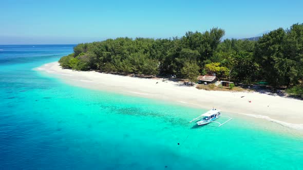 Traditional Balinese boat called Jukung anchoring on calm turquoise lagoon of quiet shore of tropica