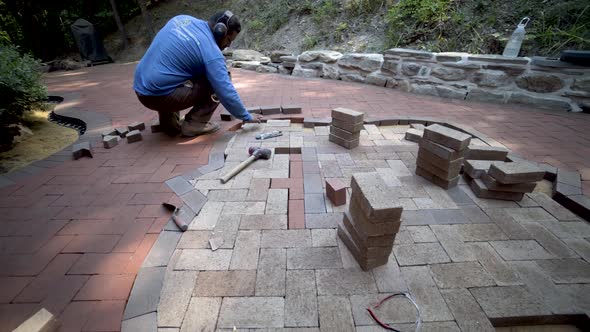 Wide angle lens shows the custom made stone wall and brick paving artisan in the distance as camera