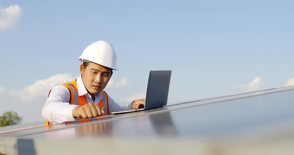 Young technician man working on laptop in solar farm