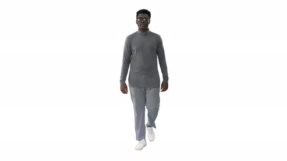 Young African American Man in Grey Casual Clothes Walking Towards Camera on White Background