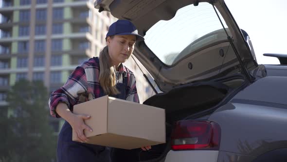 Woman Delivery Courier Taking Boxes From Car Trunk