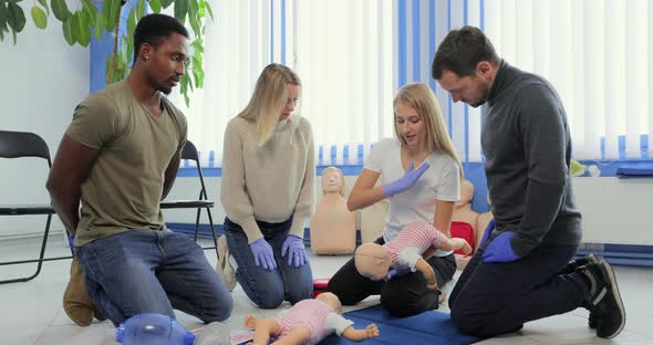 People Learning How to Safe a Life When the Baby is Choked Sitting Together with Instructor During