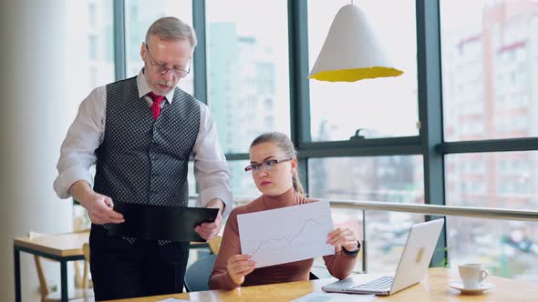 Elderly businessman and a secretary in the office