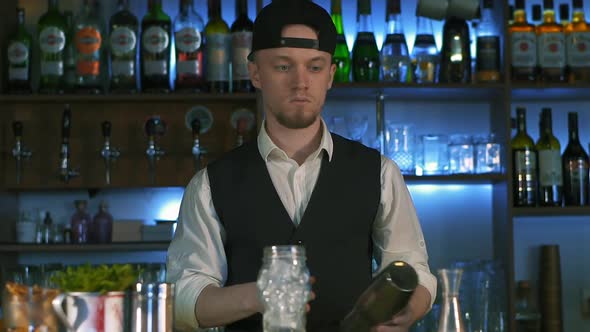 Guy-bartender Starts His Master Class of Preparation an Alcohol Cocktail.