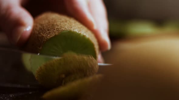 Peeling a Juicy Green Kiwi on a Black Marble Cutting Board