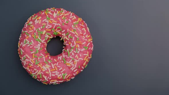 Pink Donut with Colorful Sprinkles Rotating. Colorful Doughnut Spinning