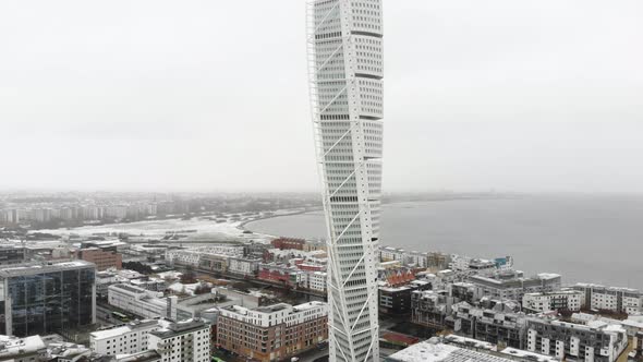 Drone flying upwards, turning torso, Malmö Sweden, wintertime while it is snowing a little