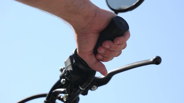 Close Up of a Man's Mitten Hand on the Handlebars of a Motorcycle