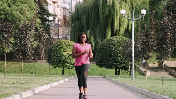 Young Active African American Woman Jogging in Park To Keep Healthy