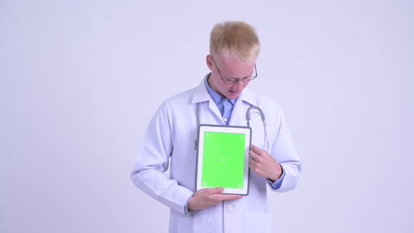 Happy Young Blonde Man Doctor Explaining While Showing Digital Tablet