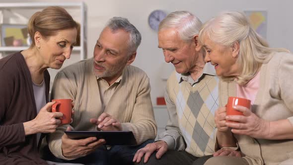 Modern Elderly Friends Using Banking App on Tablet, Smiling at Camera, Device