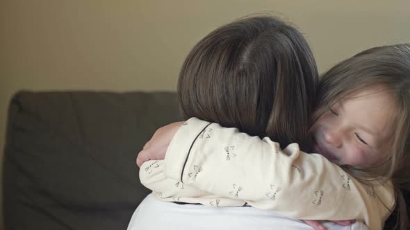 Waking Up Little Girl in Pajamas Happily Hugs Her Mother