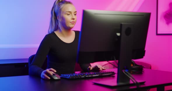 Focused Professional E-sport Gamer Girl Playing Online Video Game on PC