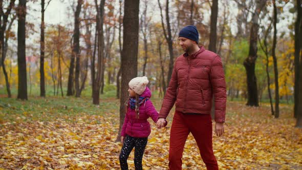 Carefree Dad and Cute Daughter Enjoying Autumn Nature