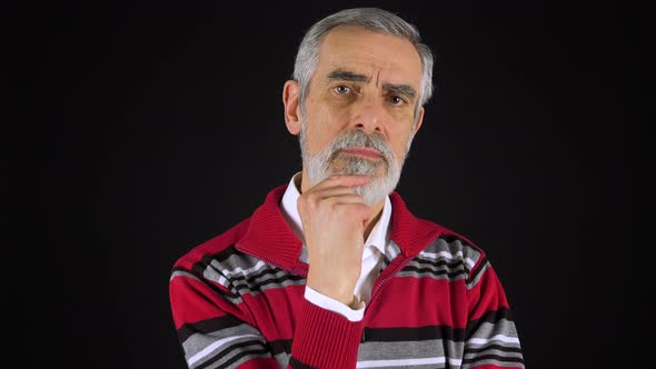 An Elderly Man Looks at the Camera with Interest - Black Screen Studio