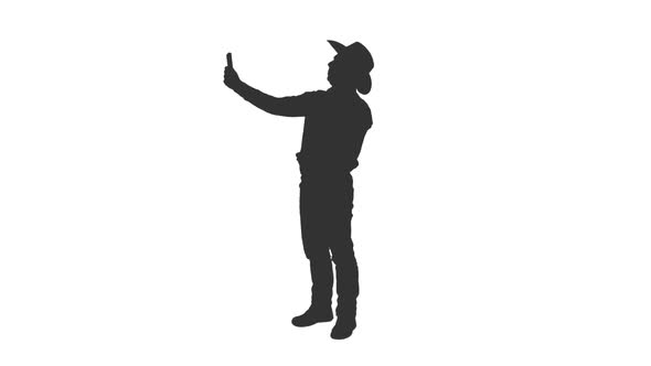 Silhouette of Male in Cowboy Hat Taking Selfie with Tablet  alt