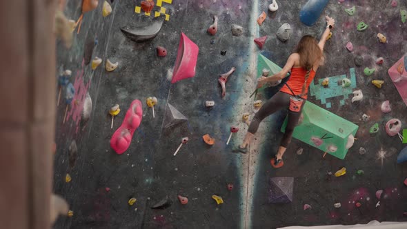 Determined woman climbing wall