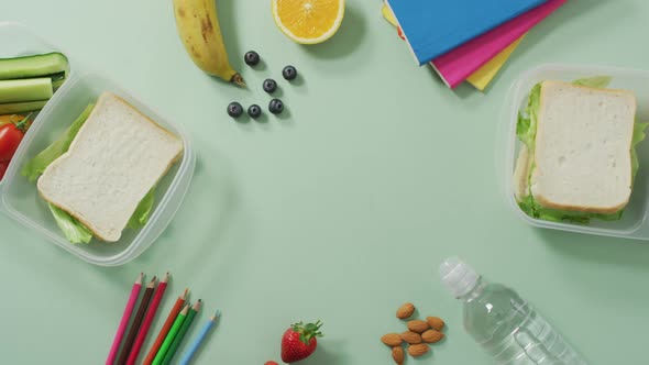 Video of healthy packed lunch of fruit and vegetables, with coloured pencils and notebooks