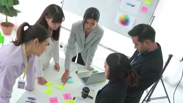 Business People Proficiently Discuss Work Project on Meeting Table