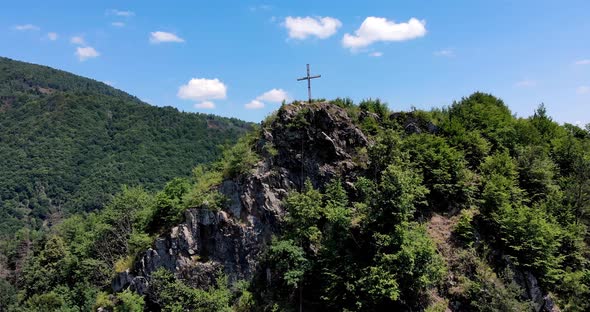 Big Cross In Top Of A Mountain In Romania On A Sunny Day - Aerial shot