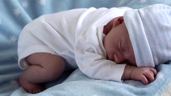 Closeup Newborn Baby Face Portrait Early Days Sleeping Sweetly On Tummy Blue Star Background