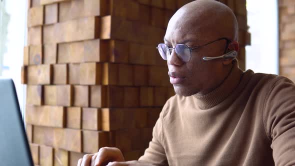 Serious Young African Man Working in a Cafe