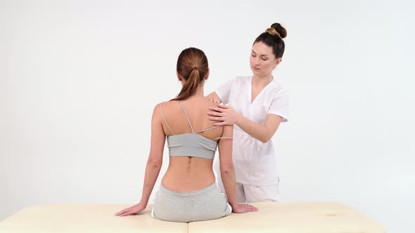 Physical Therapist Massaging Shoulder of a Female Patient.