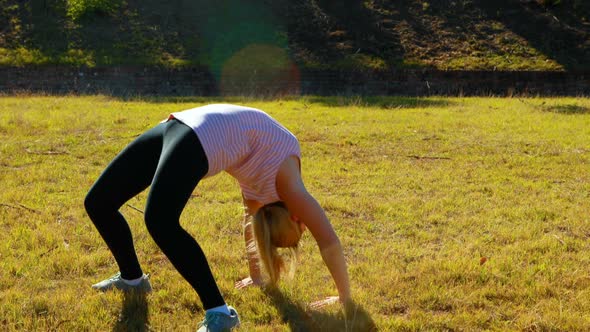 Woman performing stretching exercise during obstacle course