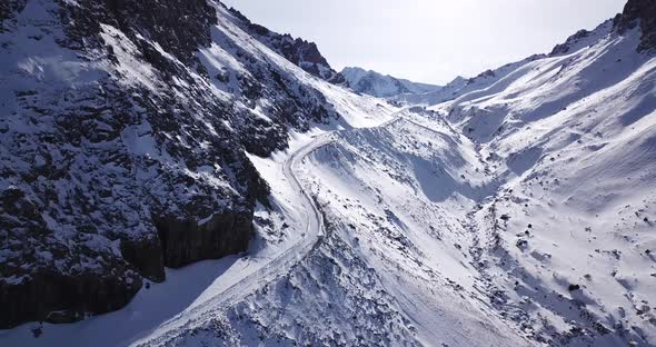 A Group of People Climb a Snow Path in the Gorge