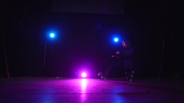 Professional Roller Skater Girl Crouches on Rear and Front Wheels in Scene, Approaching View of Pink