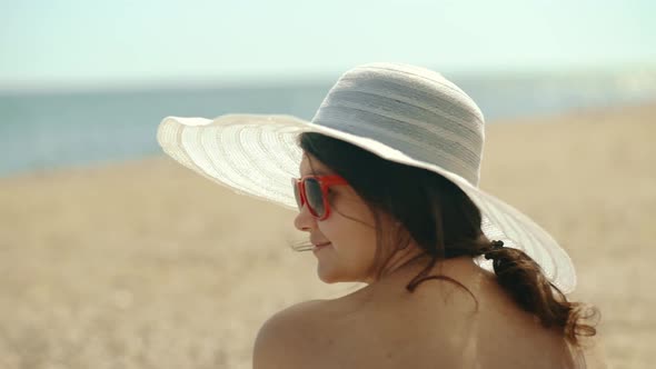 Beautiful Woman is Resting on the Beach and Looking at the Sea