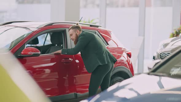 Confident Man Examining Luxurious Pricey Car in Dealership