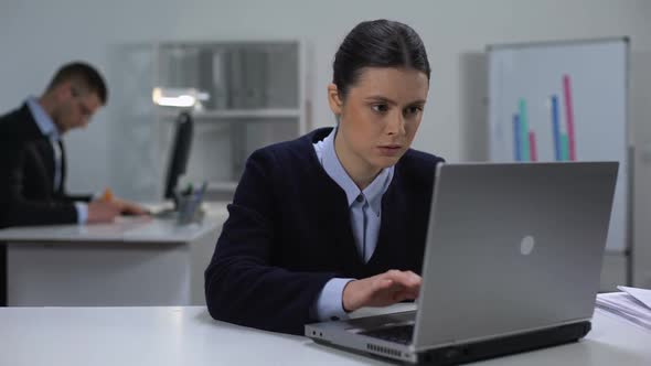 Concentrated Female Manager Texting on Laptop