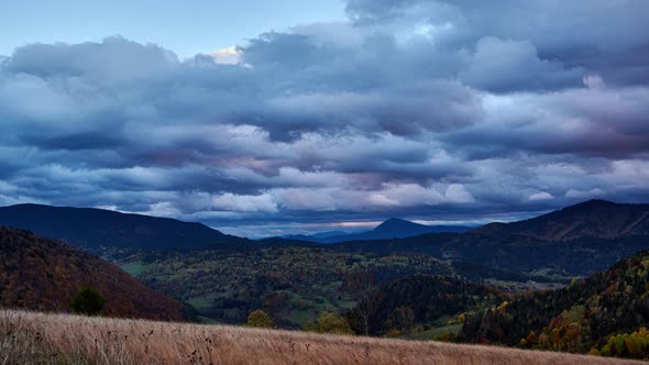 Thick clouds at sunset. Colorful trees in autumn.Autumn rural landscape at dusk. 4K