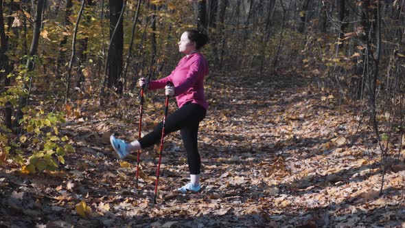 Stretching exercises with nordic walking poles before training in city autumn park. Weight loss