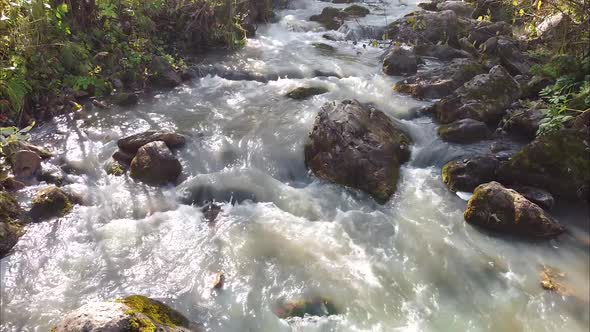 Closeup of a Mountain River Flight of an Unmanned Camera Directly Over the Water of a Mountain River