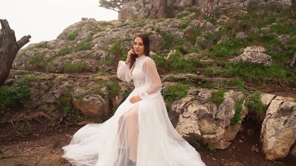 Photo Shoot of a Model in a Wedding Dress in the Mountains in Cold Foggy Weather