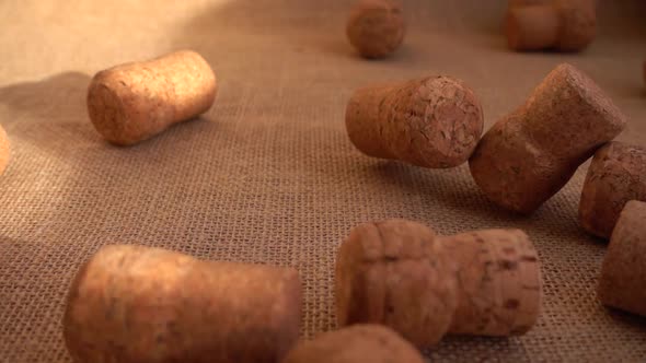 Champagne wine corks fall onto the burlap. Slow motion.